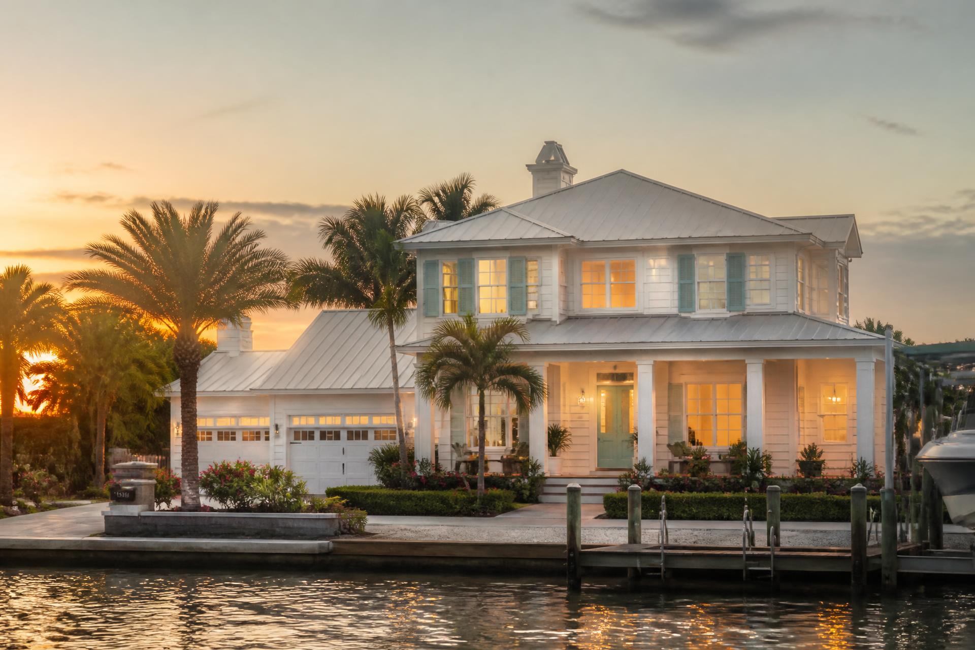 Central Florida coastal home at dusk with palm trees and warm interior light